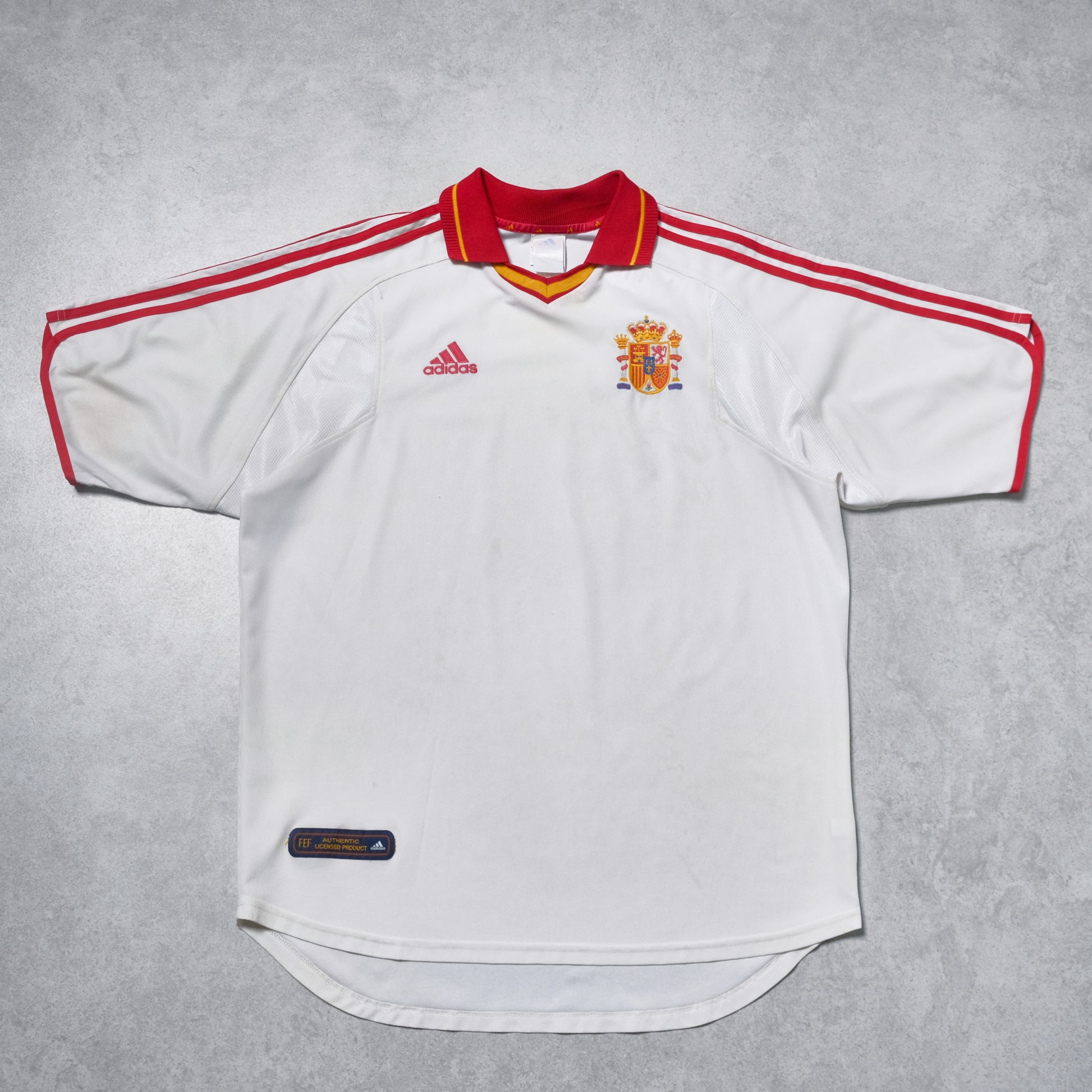 White soccer jersey with red accents and Adidas logo on a gray background