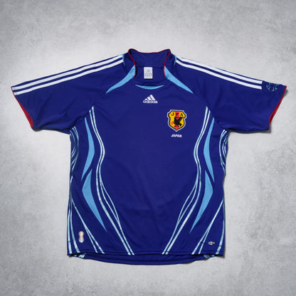 Blue sports jersey with Adidas logo and Japanese flag on a gray background