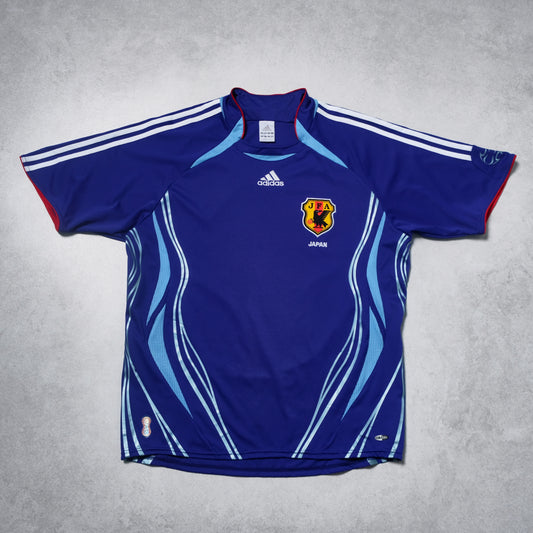 Blue sports jersey with Adidas logo and Japanese flag on a gray background