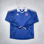 Blue long-sleeve sports jersey with Adidas logo on a gray background