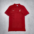 Red polo shirt with Nike and Liverpool FC logos on a gray background