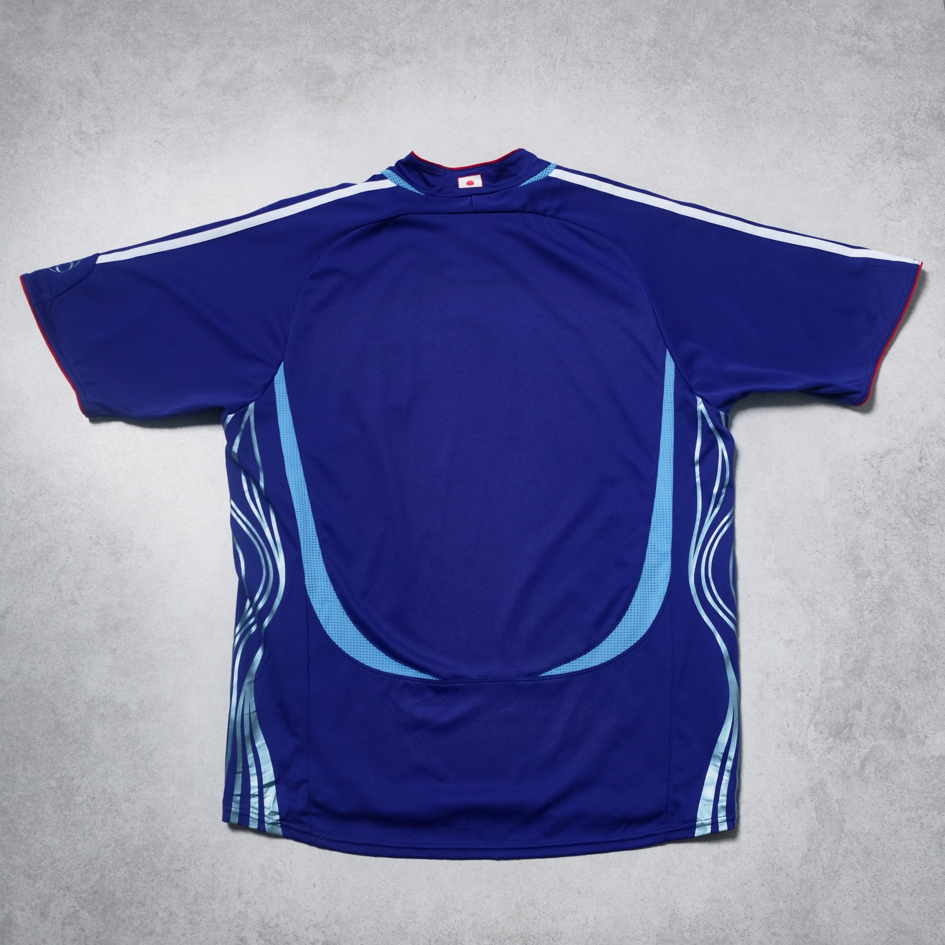 Blue sports jersey with white and red accents on a gray background