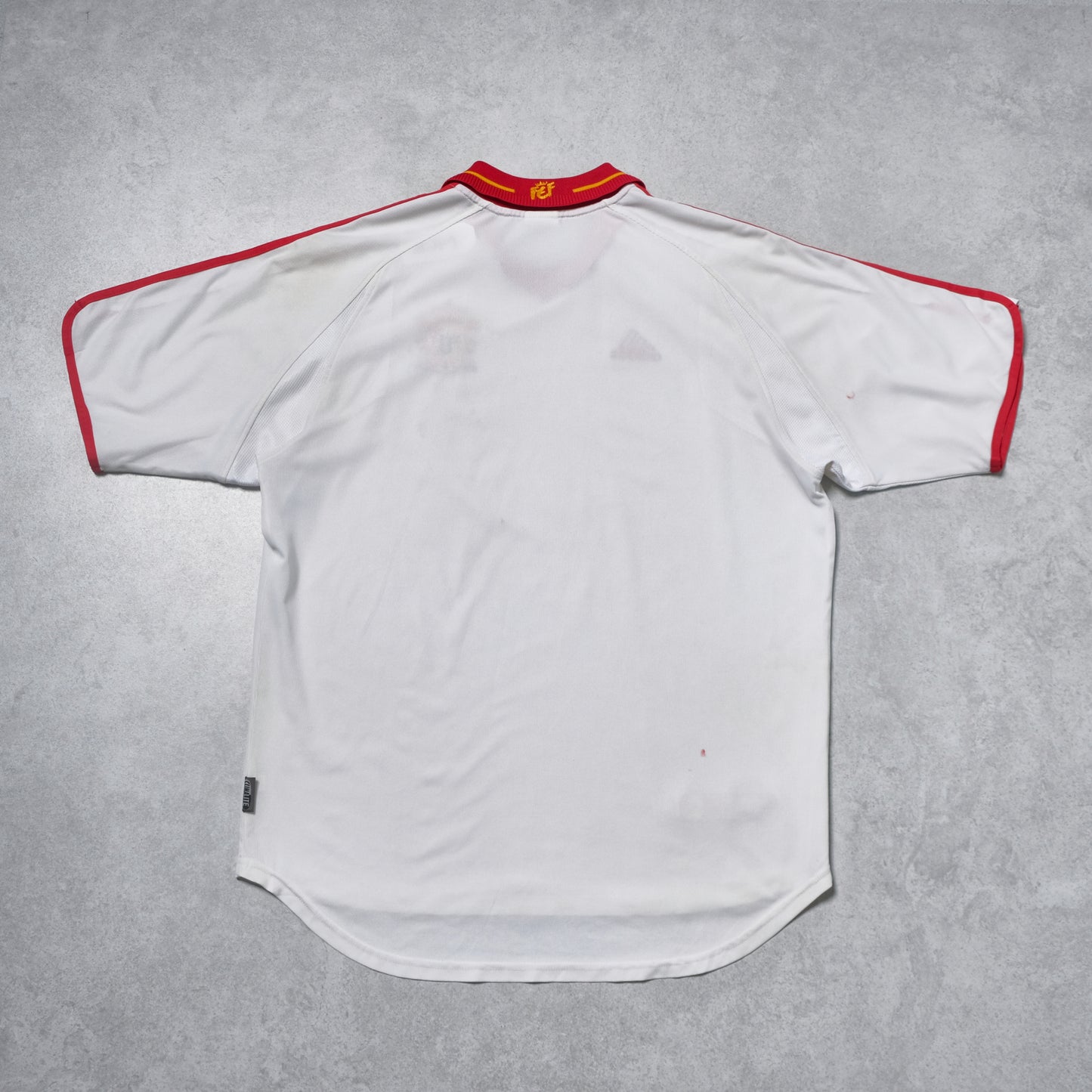 White sports jersey with red accents on a gray background