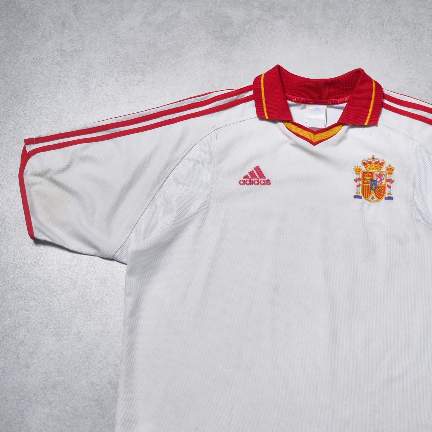 White sports jersey with red accents and Adidas logo on a gray background