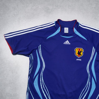 Blue sports jersey with Adidas logo and Japan emblem on a gray background