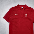 Red polo shirt with Nike and Liverpool FC logos on a gray background