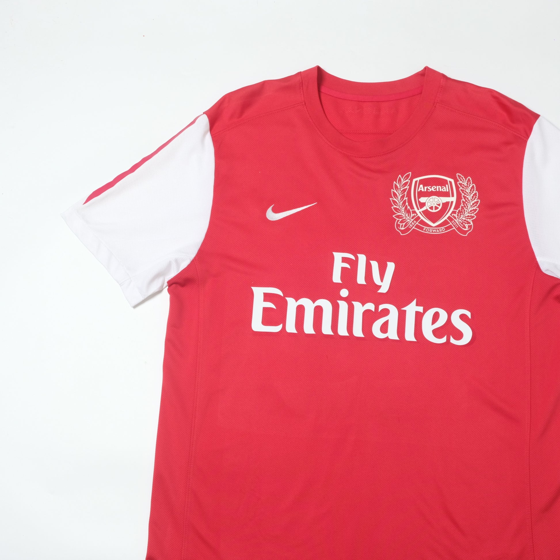 Red sleeveless sports jersey with Nike logo and Arsenal branding on a white background