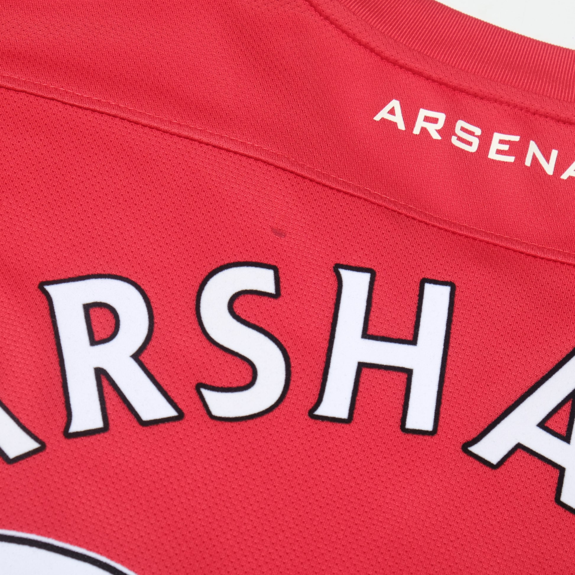 Red sports jersey with 'Arsenal' branding and visible text